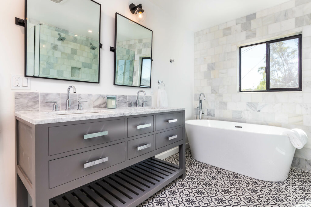 Modern bathroom with patterned tile flooring, tiled walls, a freestanding bathtub, and double vanity | Dalton Flooring of Georgia
